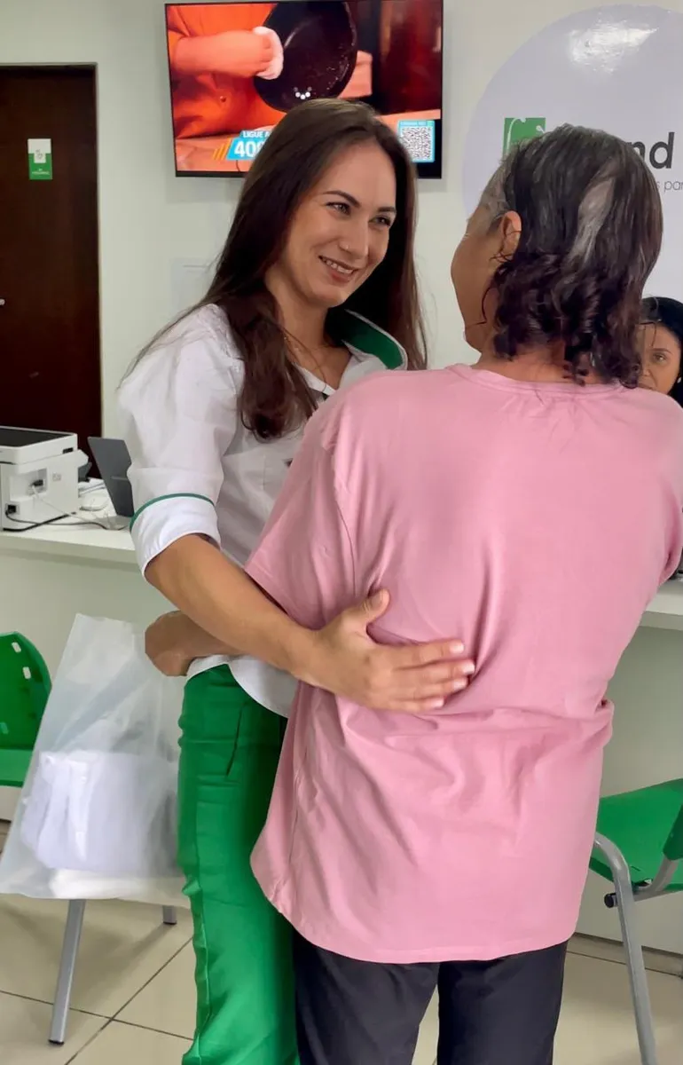 Recepcionista da Atend Já acolhendo paciente com um abraço